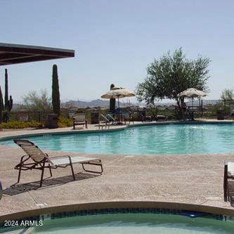 community pool with a patio area and fence