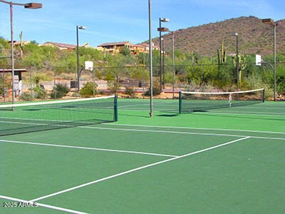 view of tennis court featuring fence and a mountain view