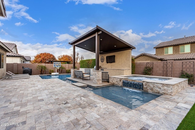 view of pool with a patio, pool water feature, and an in ground hot tub