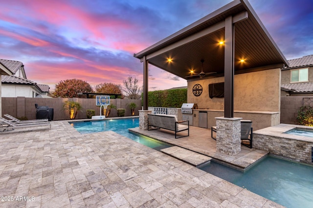 pool at dusk featuring an in ground hot tub, area for grilling, ceiling fan, and a patio area