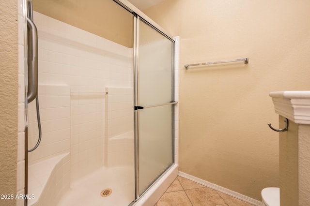 14950 W Mountain View Blvd Unit 7209, Surprise, AZ 85374 - bathroom with a stall shower, tile patterned flooring, toilet, and baseboards