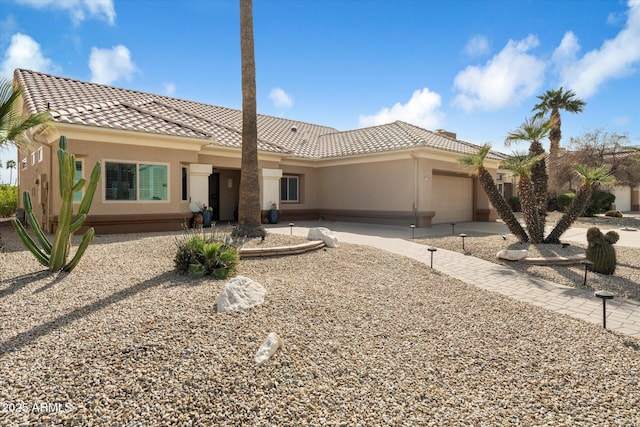 view of front of home featuring a garage, concrete driveway, a tile roof, and stucco siding