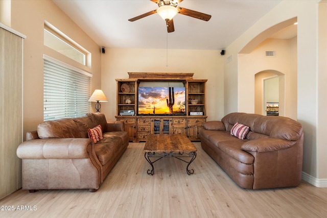 living room with ceiling fan, visible vents, arched walkways, and wood finished floors