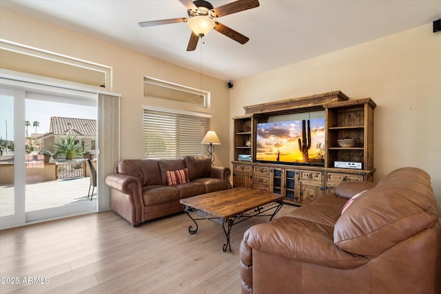 living room featuring a healthy amount of sunlight, ceiling fan, and light wood-style flooring