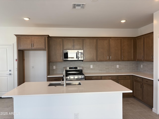18001 W Lupine Ave, Goodyear, AZ 85338 - kitchen featuring appliances with stainless steel finishes, a sink, backsplash, light tile patterned flooring, and light countertops