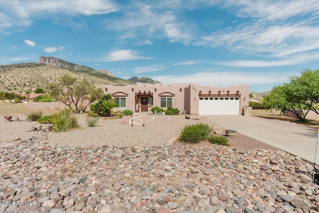 pueblo revival-style home featuring a mountain view and a garage