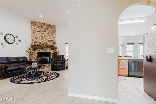 living room featuring light tile patterned floors and a stone fireplace