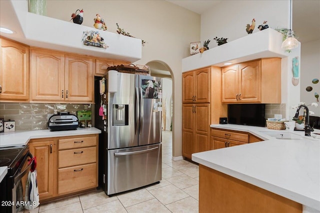 kitchen with black range with electric stovetop, sink, tasteful backsplash, stainless steel fridge, and pendant lighting