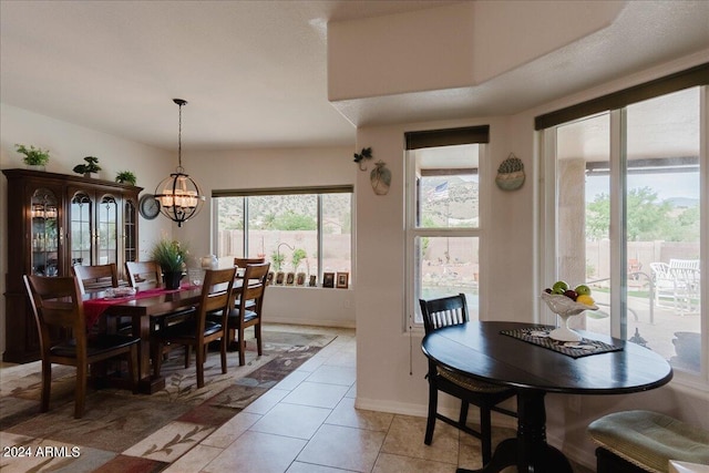 dining area with plenty of natural light, light tile patterned floors, and an inviting chandelier