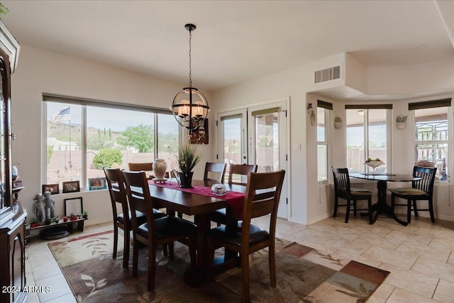 dining room featuring light tile patterned floors, a healthy amount of sunlight, and a notable chandelier