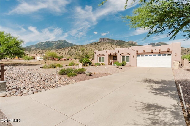 pueblo-style home featuring a mountain view and a garage