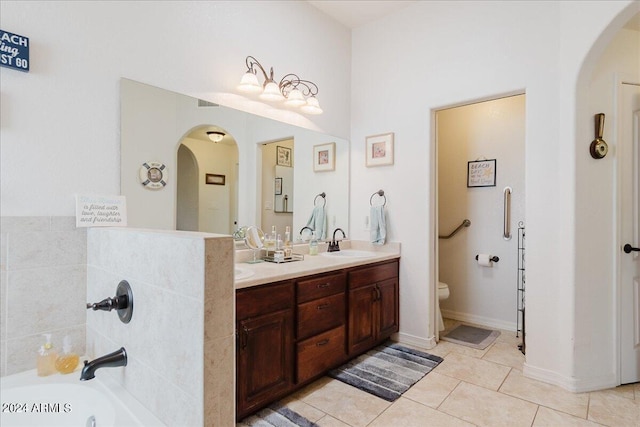 bathroom with tile patterned flooring, vanity, toilet, and a bathing tub