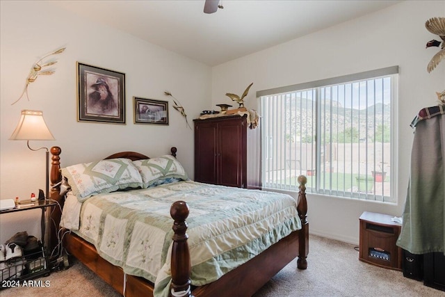 bedroom featuring multiple windows, ceiling fan, and light colored carpet