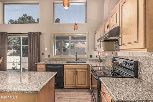 kitchen with tasteful backsplash, a sink, light stone counters, black appliances, and under cabinet range hood