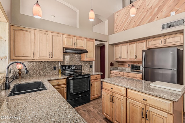 kitchen featuring visible vents, appliances with stainless steel finishes, light stone countertops, a sink, and under cabinet range hood