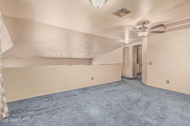 bonus room featuring ceiling fan, a textured ceiling, carpet, vaulted ceiling, and visible vents