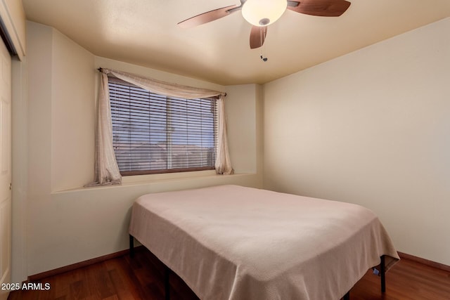 bedroom featuring baseboards, ceiling fan, and dark wood-style flooring