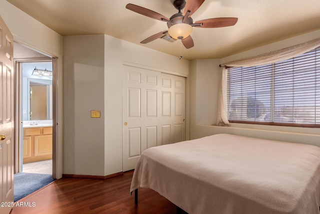 bedroom featuring baseboards, multiple windows, wood finished floors, and a closet