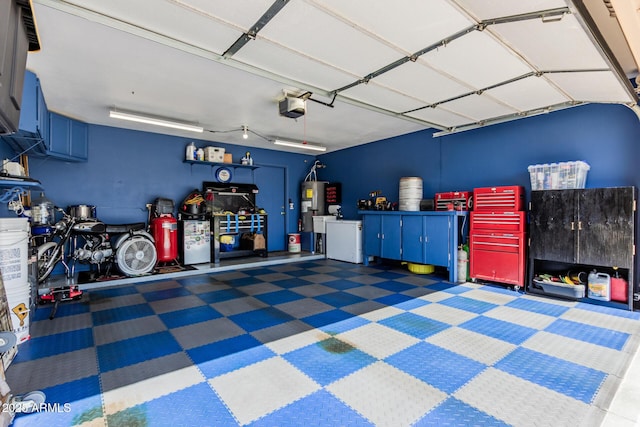 garage featuring water heater, a garage door opener, and washer / clothes dryer