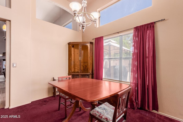 dining space with baseboards, a high ceiling, a chandelier, and dark carpet