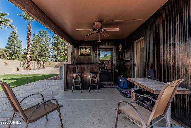 view of patio featuring a ceiling fan, a fenced backyard, and outdoor dry bar