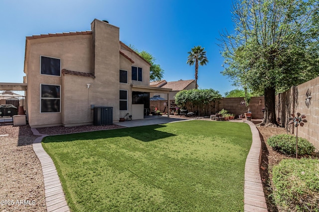 view of yard featuring a fenced backyard, central air condition unit, and a patio area