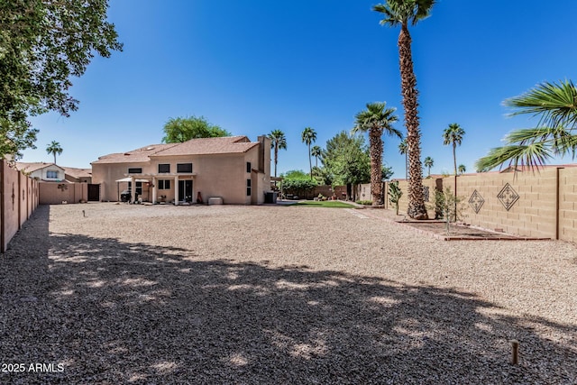 back of house featuring a fenced backyard and stucco siding