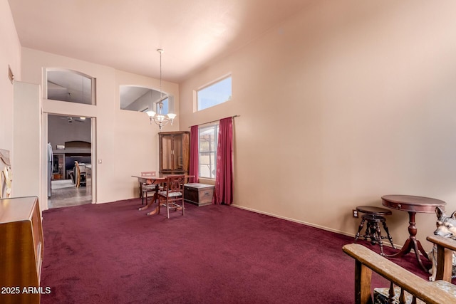 dining room featuring a high ceiling, a notable chandelier, and carpet