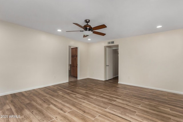 spare room featuring a ceiling fan, visible vents, wood finished floors, baseboards, and recessed lighting