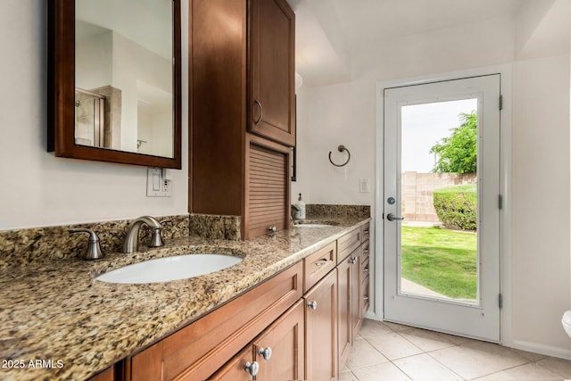 bathroom featuring a sink, tile patterned floors, toilet, and double vanity