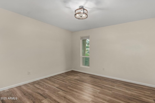 empty room with baseboards and wood finished floors
