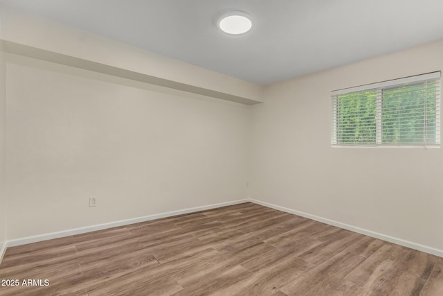 unfurnished room with baseboards and wood finished floors