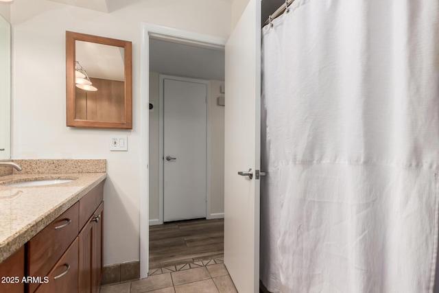 bathroom featuring vanity, baseboards, and tile patterned floors