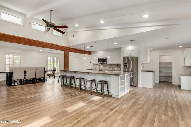 kitchen with visible vents, open shelves, beamed ceiling, a ceiling fan, and stainless steel appliances