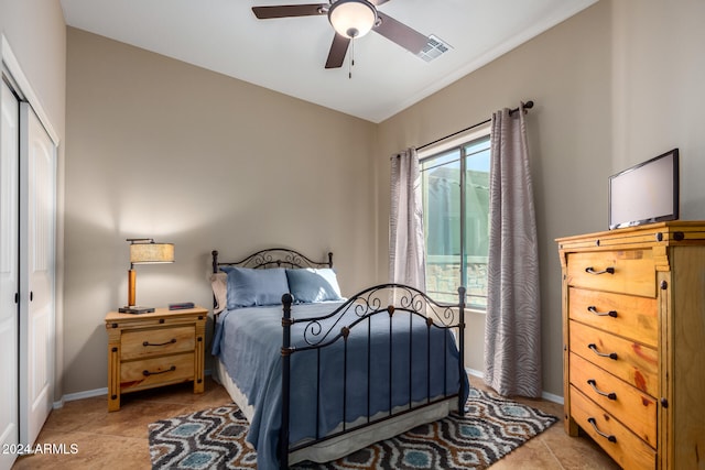 tiled bedroom featuring ceiling fan and a closet