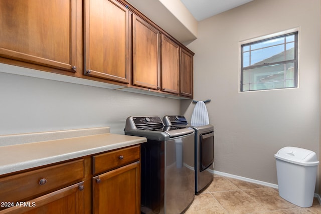 washroom with cabinets, independent washer and dryer, and light tile patterned floors