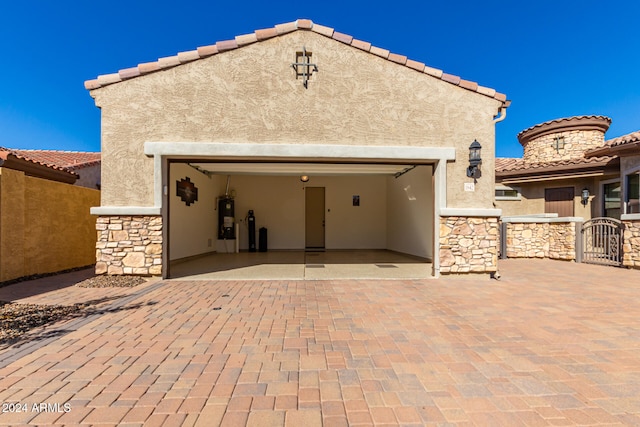 rear view of house with a garage and water heater