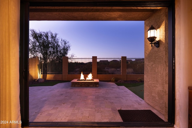 patio terrace at dusk featuring an outdoor fire pit