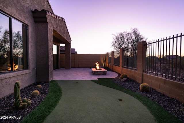 yard at dusk with a patio area and a fire pit