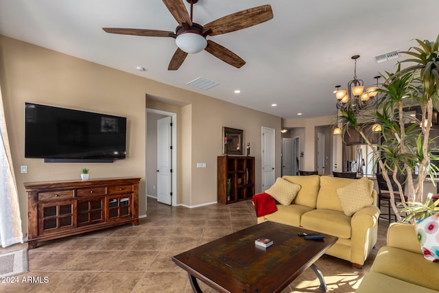 tiled living room with ceiling fan with notable chandelier