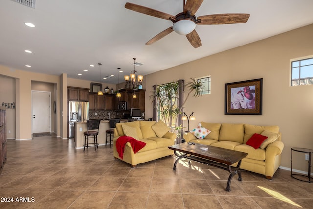 living room with ceiling fan with notable chandelier and light tile patterned flooring