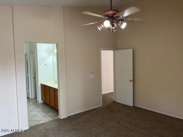 interior space featuring light tile patterned floors, ceiling fan, and a high ceiling