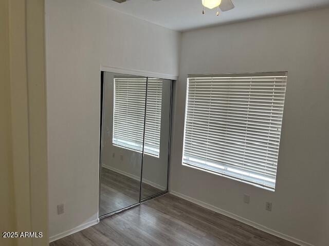 unfurnished bedroom featuring ceiling fan, a closet, and hardwood / wood-style flooring