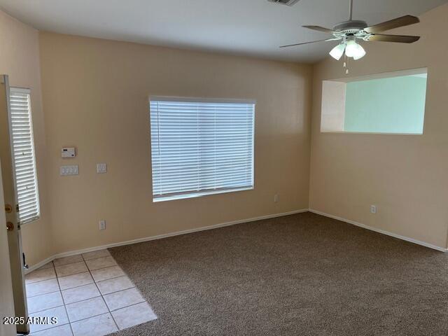 tiled spare room featuring ceiling fan