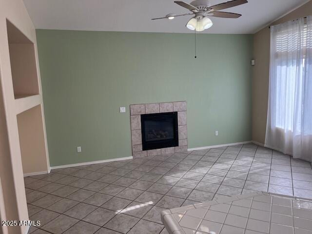 unfurnished living room with ceiling fan, light tile patterned floors, and a tiled fireplace