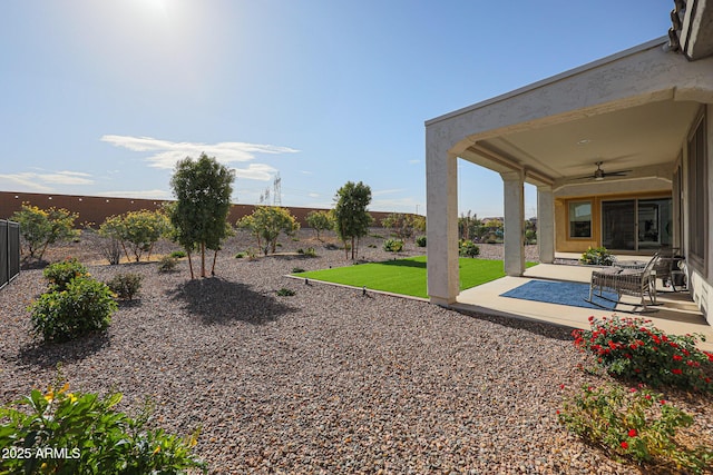 view of yard with a ceiling fan, a fenced backyard, and a patio