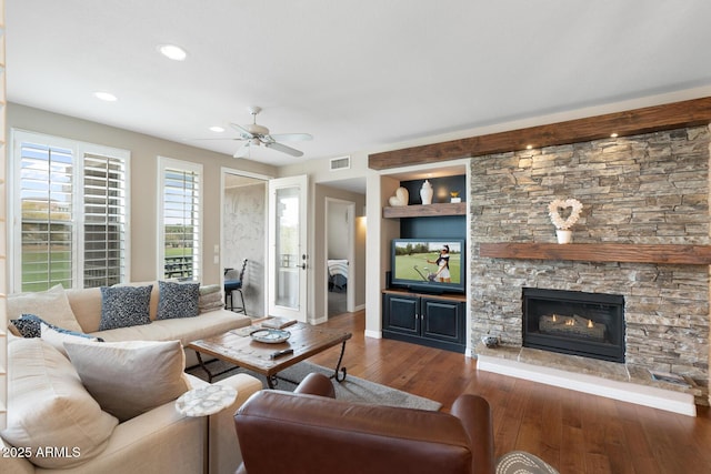 living area with built in features, visible vents, a fireplace, ceiling fan, and hardwood / wood-style flooring