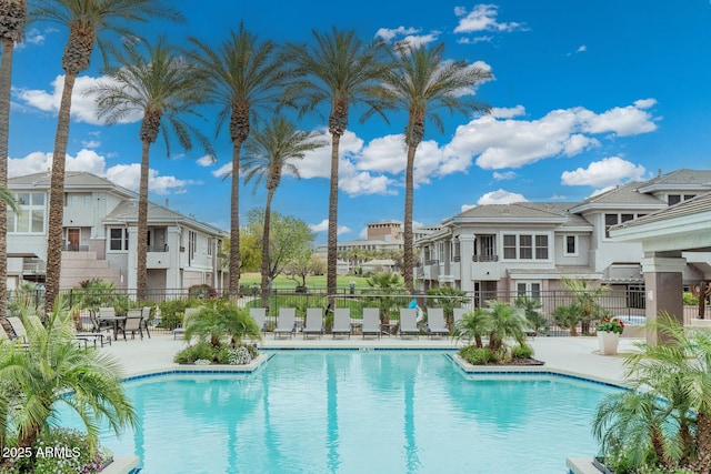 pool with a residential view, a patio, and fence