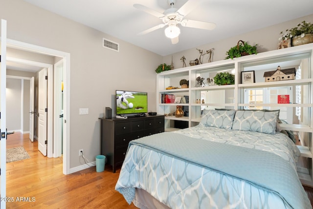 bedroom with light wood finished floors, visible vents, ceiling fan, and baseboards