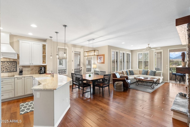 kitchen with a sink, decorative light fixtures, tasteful backsplash, and hardwood / wood-style floors